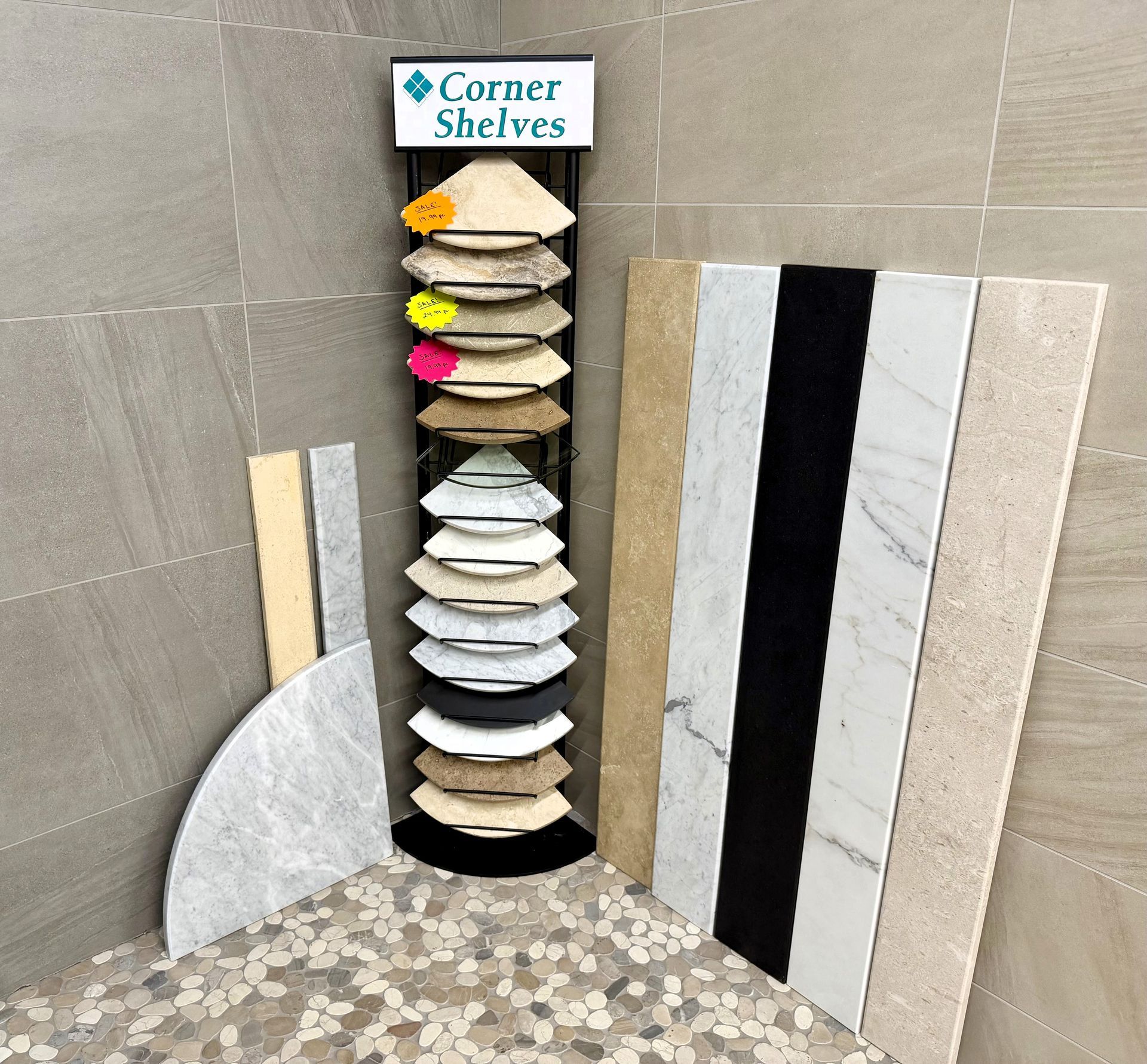 Corner shelf display of white and colored samples beside gray and marble wall panels