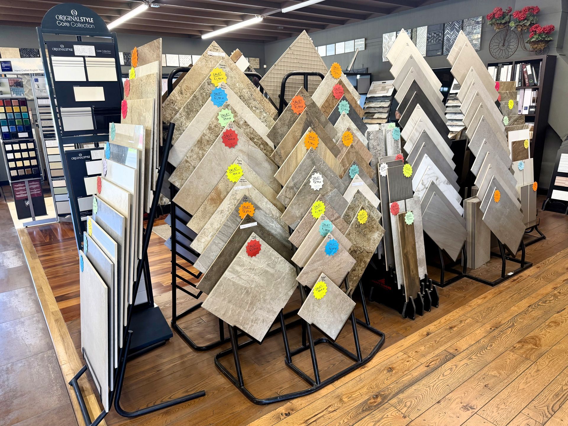 Display of patterned rugs and floor mats in a store, with colorful sale tags on diamond-shaped samples.