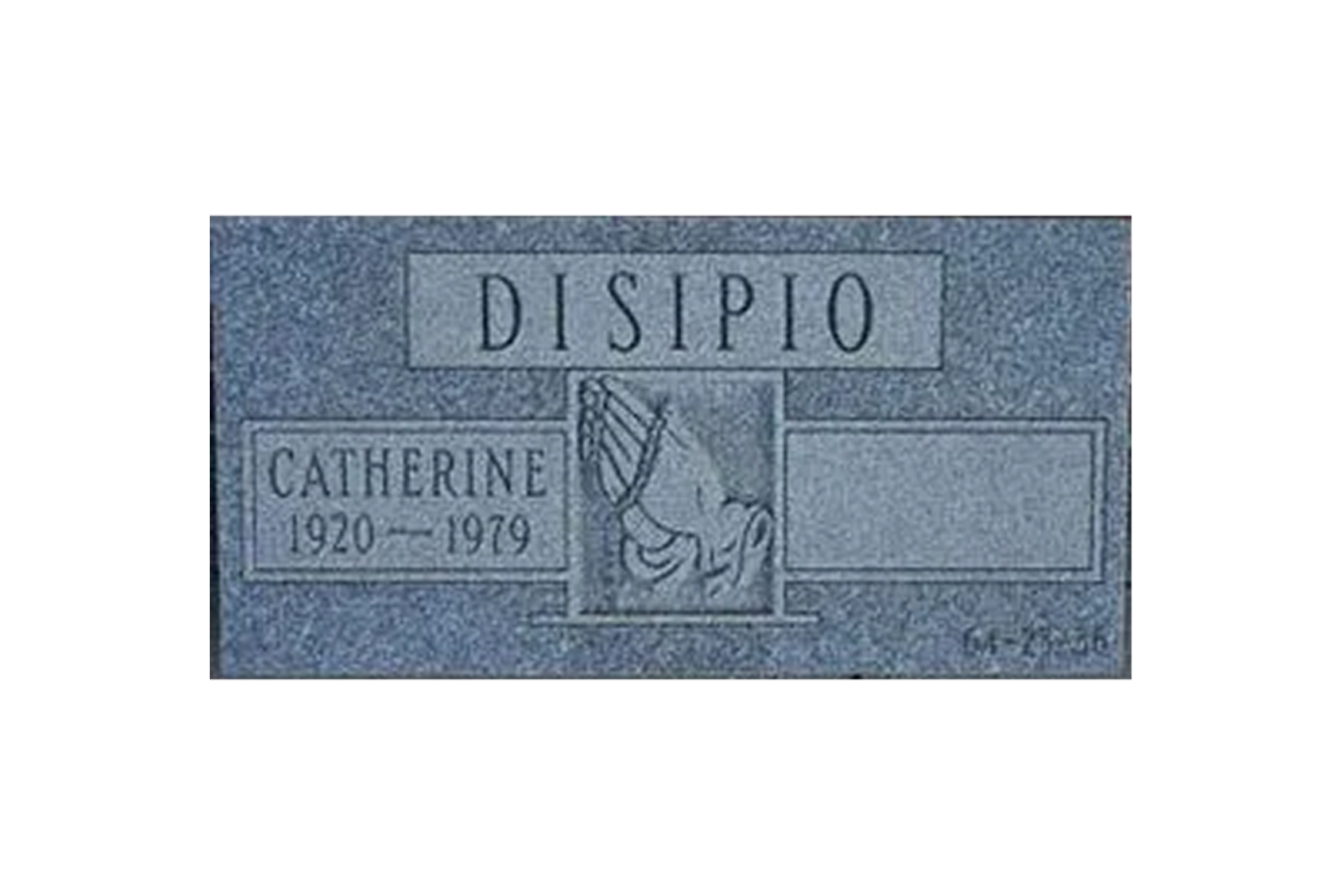 A gravestone for a woman named disipio is sitting in front of a brick wall.