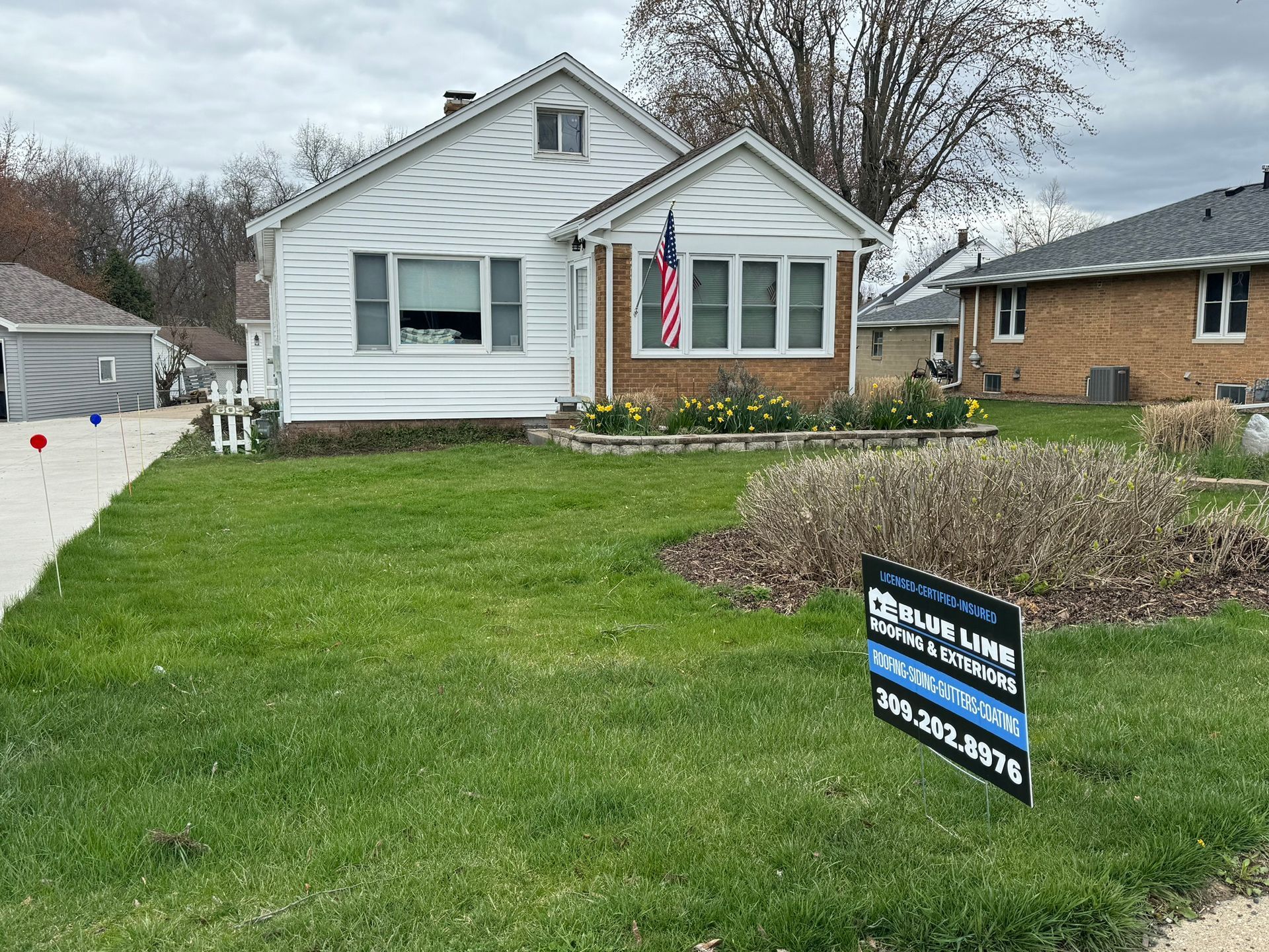 A house with a for sale sign in front of it.