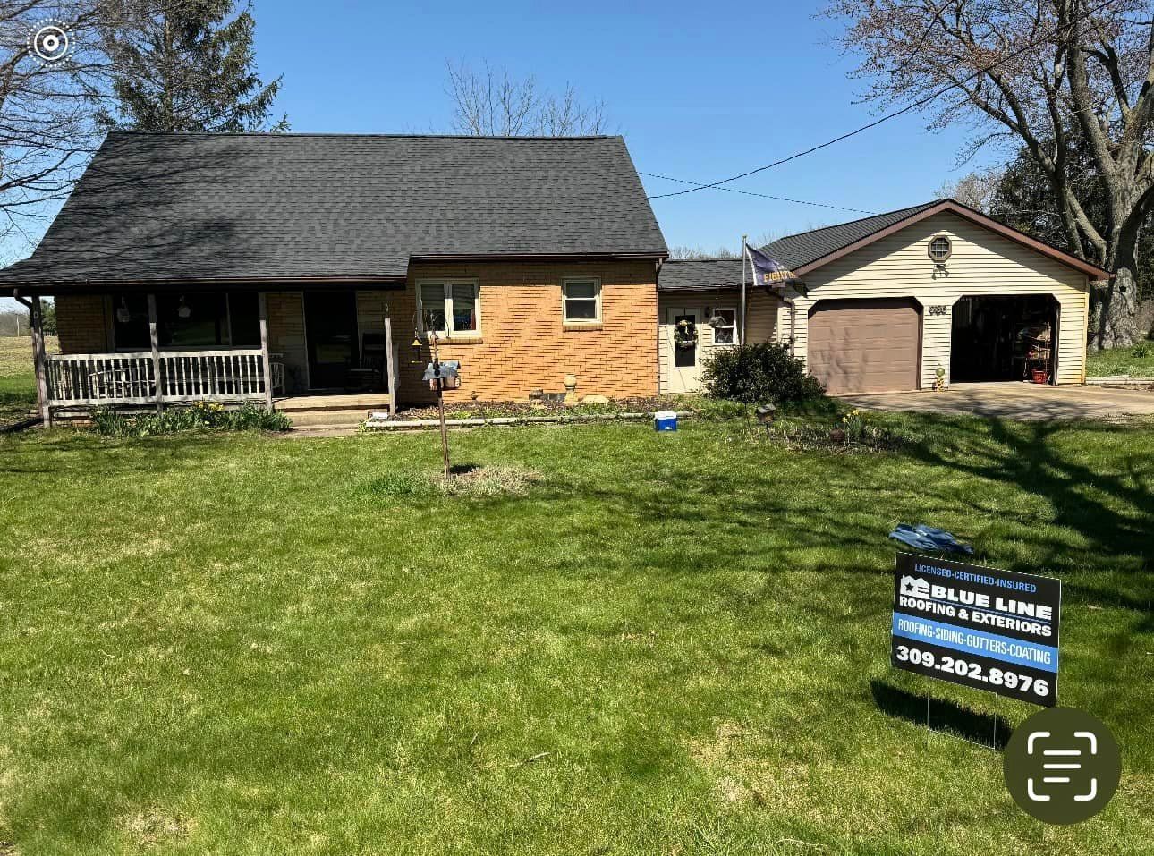 A house for sale with a sign in front of it.