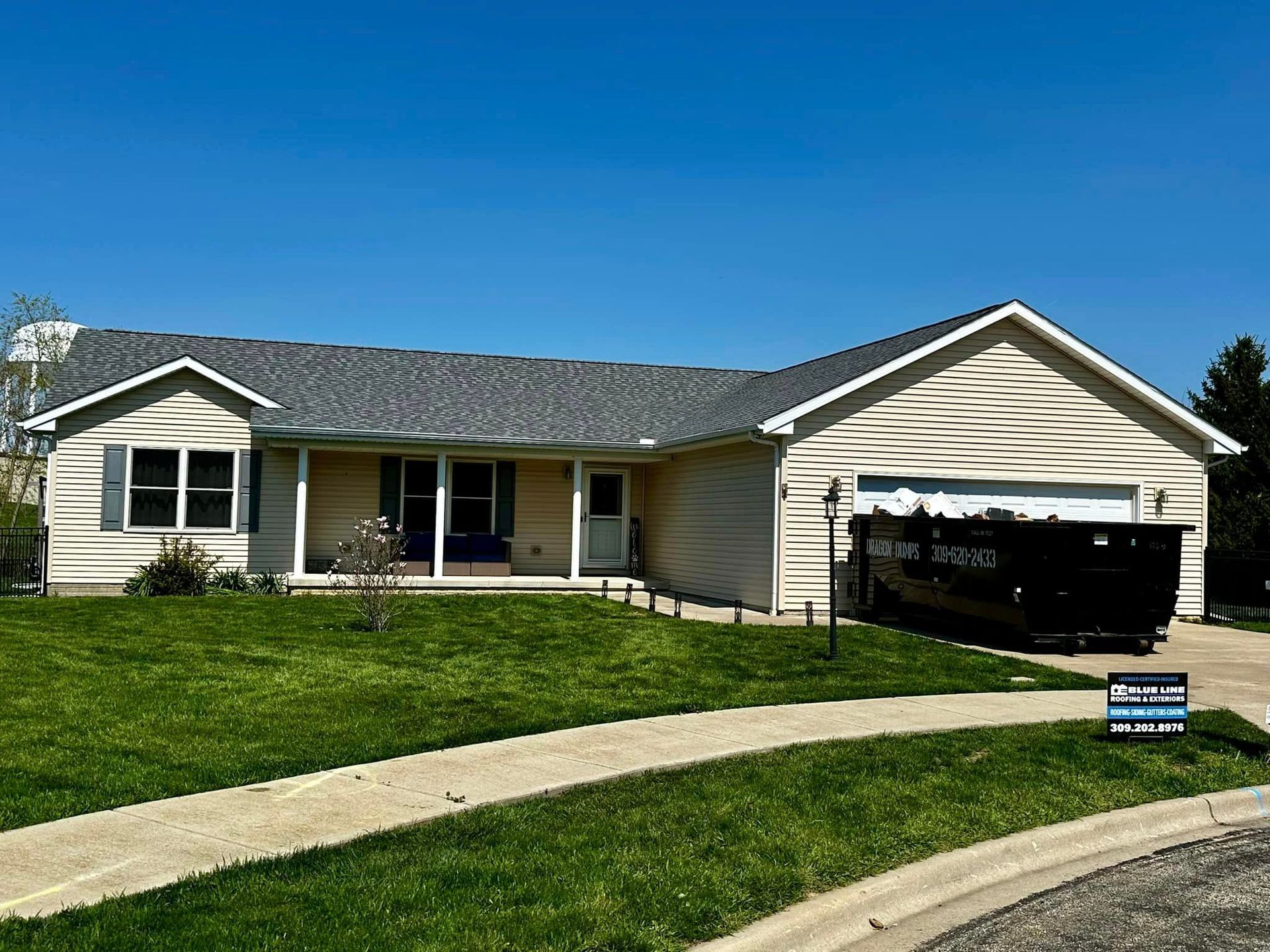 A house with a gray roof is for sale