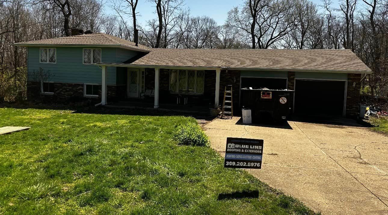 A house with a large lawn and a driveway in front of it.