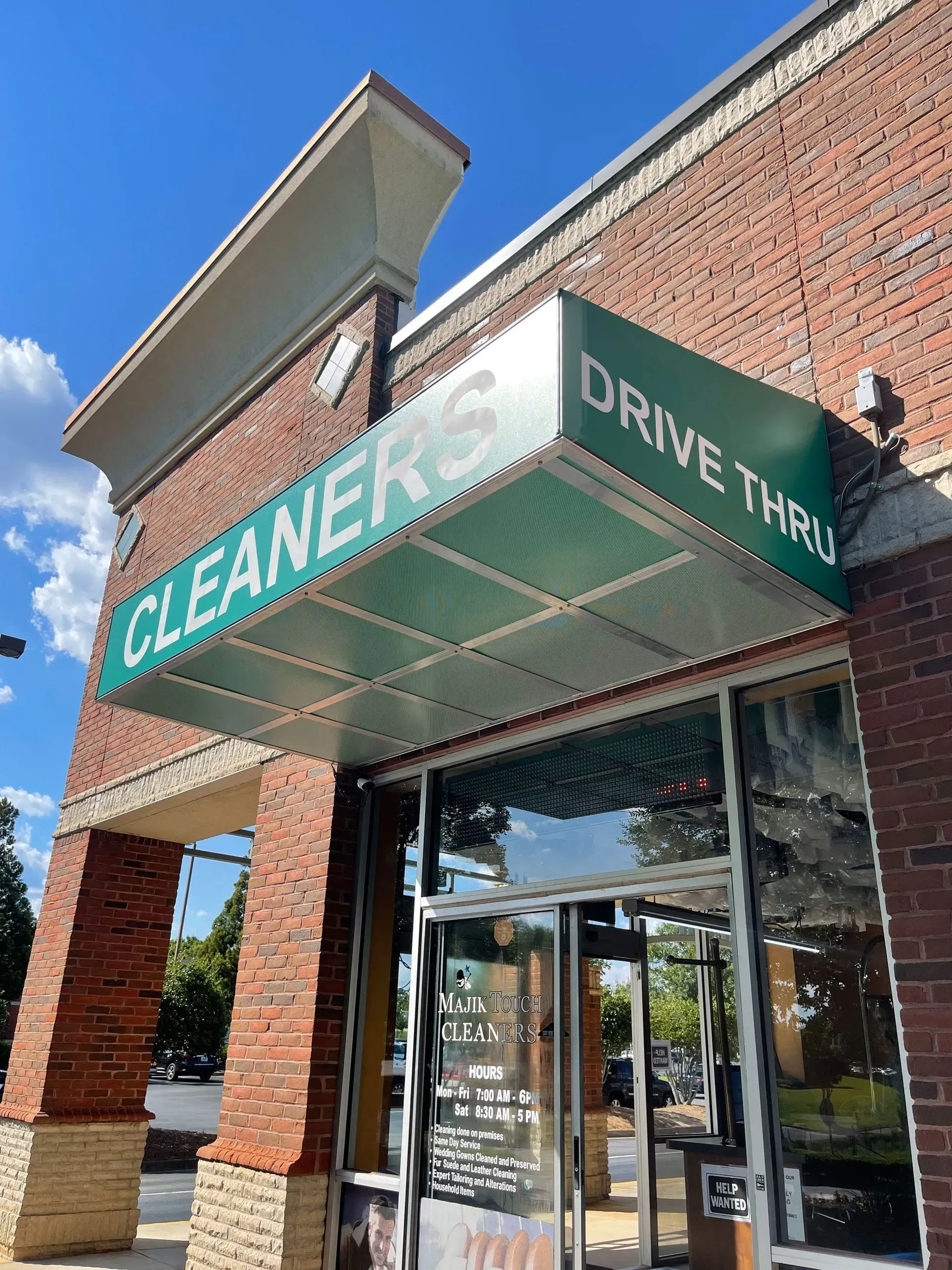 A brick building with "CLEANERS DRIVE THRU" sign above the door.