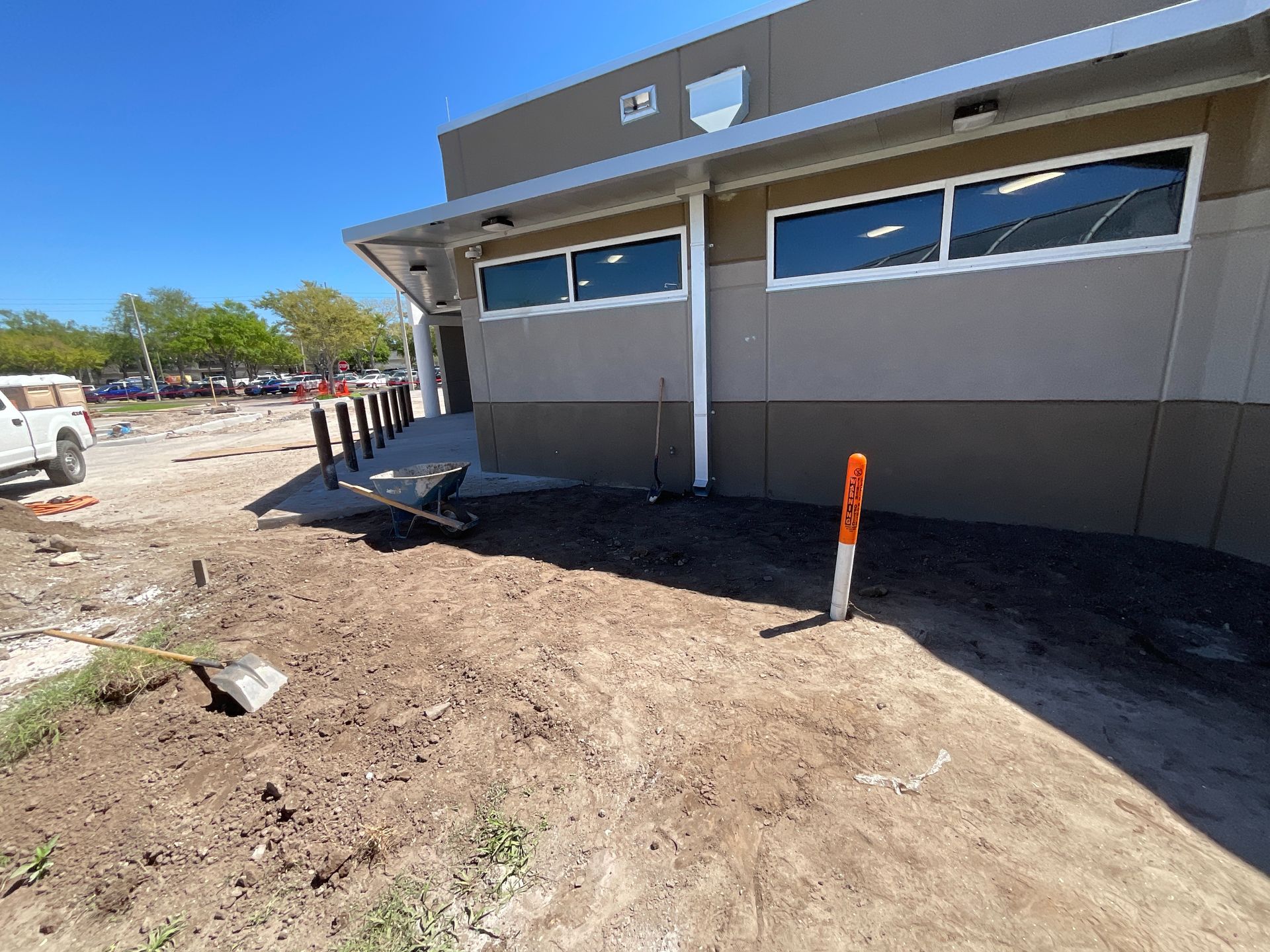 Building exterior with construction site, tan and brown walls, blue sky.