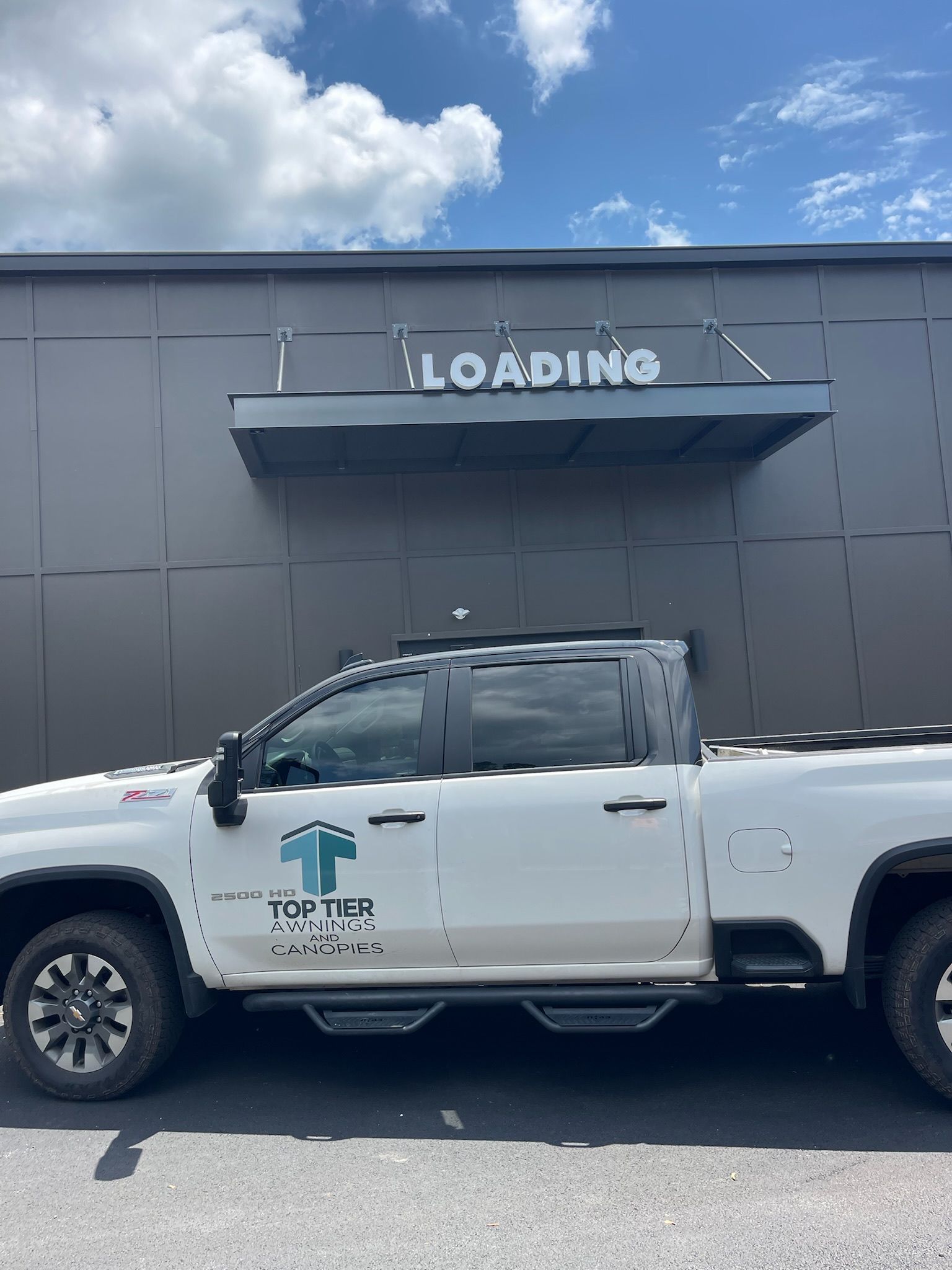 White pickup truck parked in front of a building with 