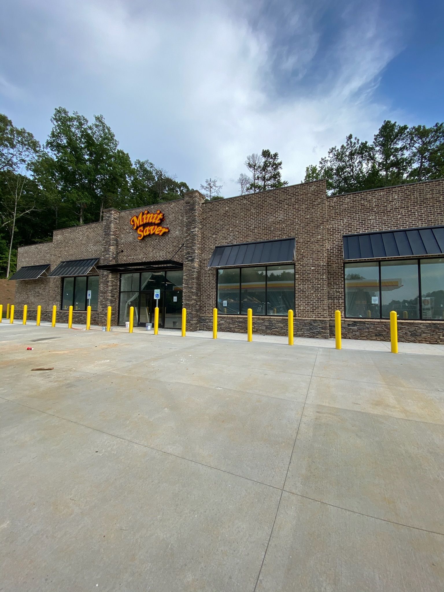 A brick building with black awnings, yellow bollards, and the words 