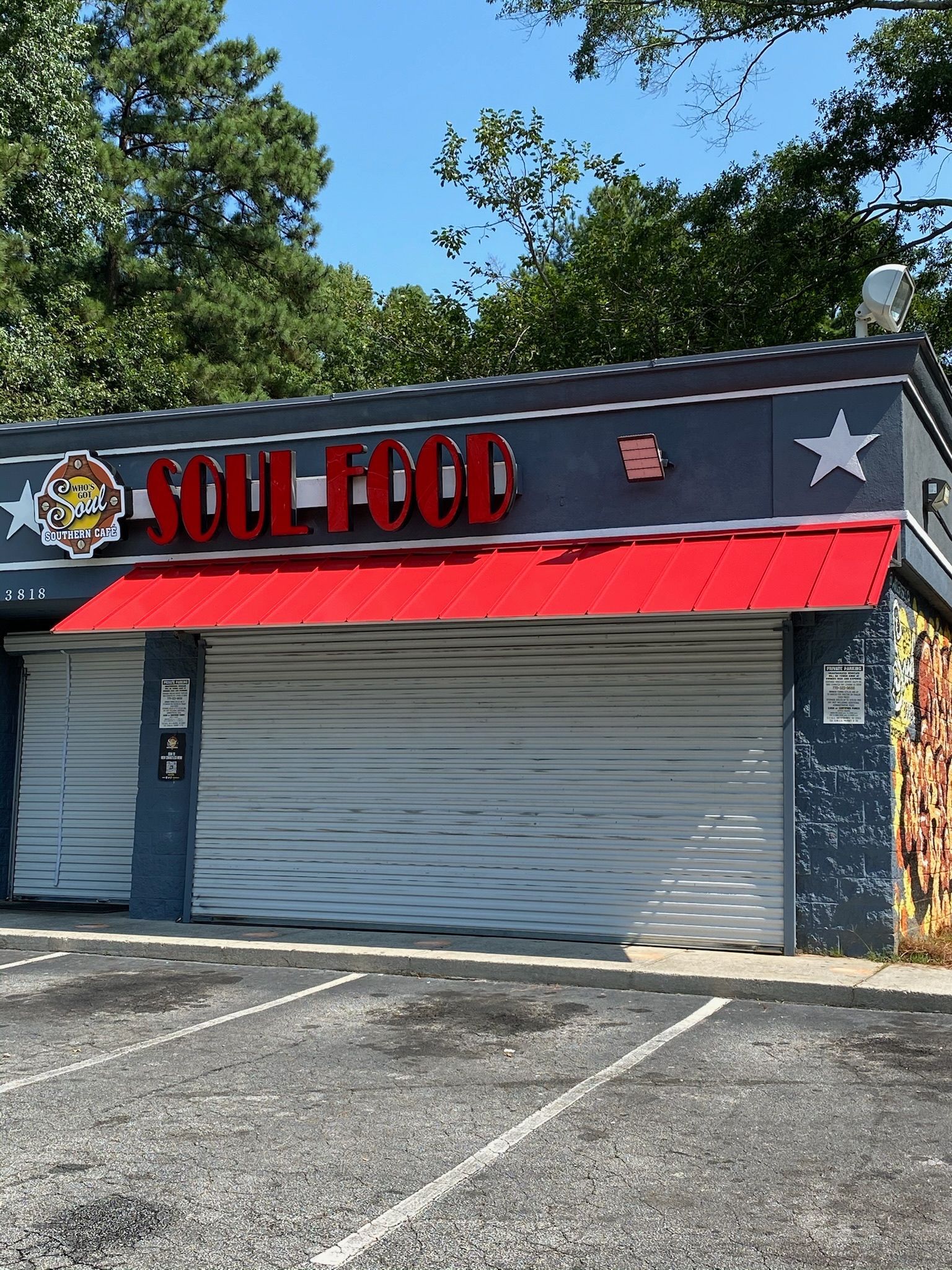 Soul Food restaurant with closed metal shutters and red awning.