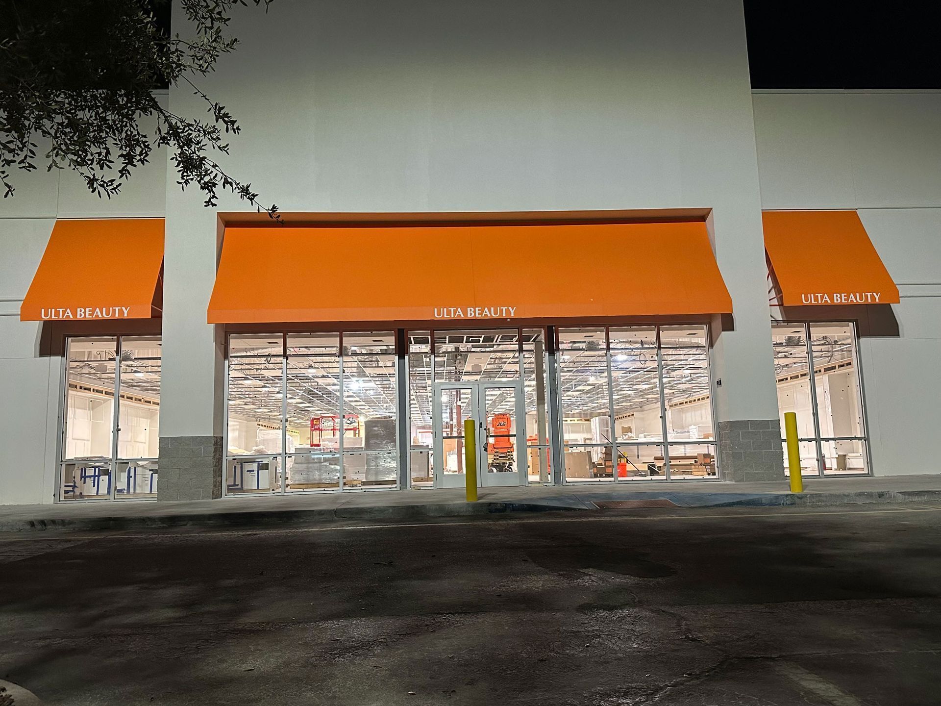 Storefront at night with orange awnings and bright interior.