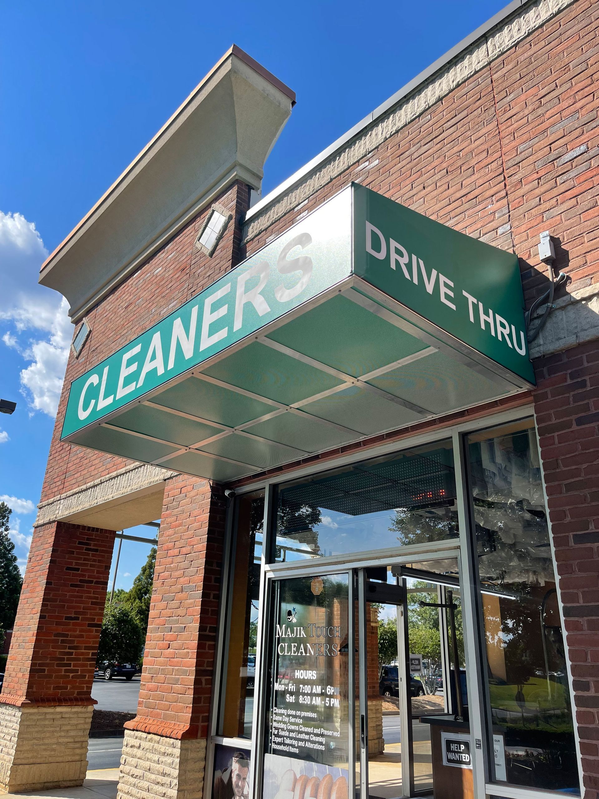 Green awning over a brick building entrance reading