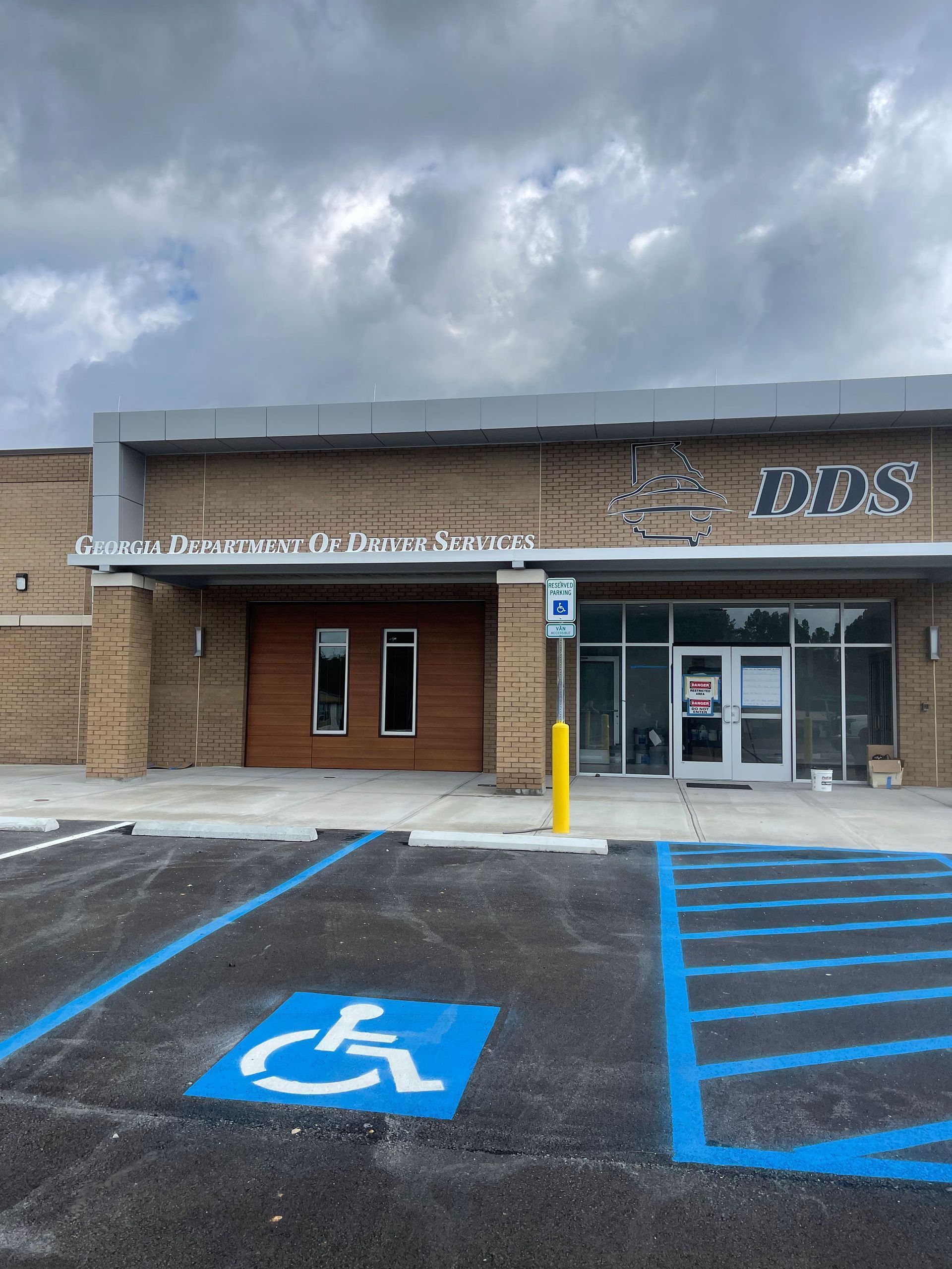 Exterior of a building with accessible parking. Sign reads