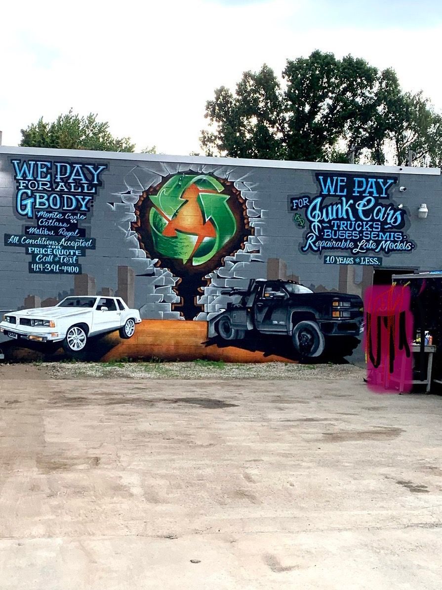 A mural on the side of a building that says we pay junk cars