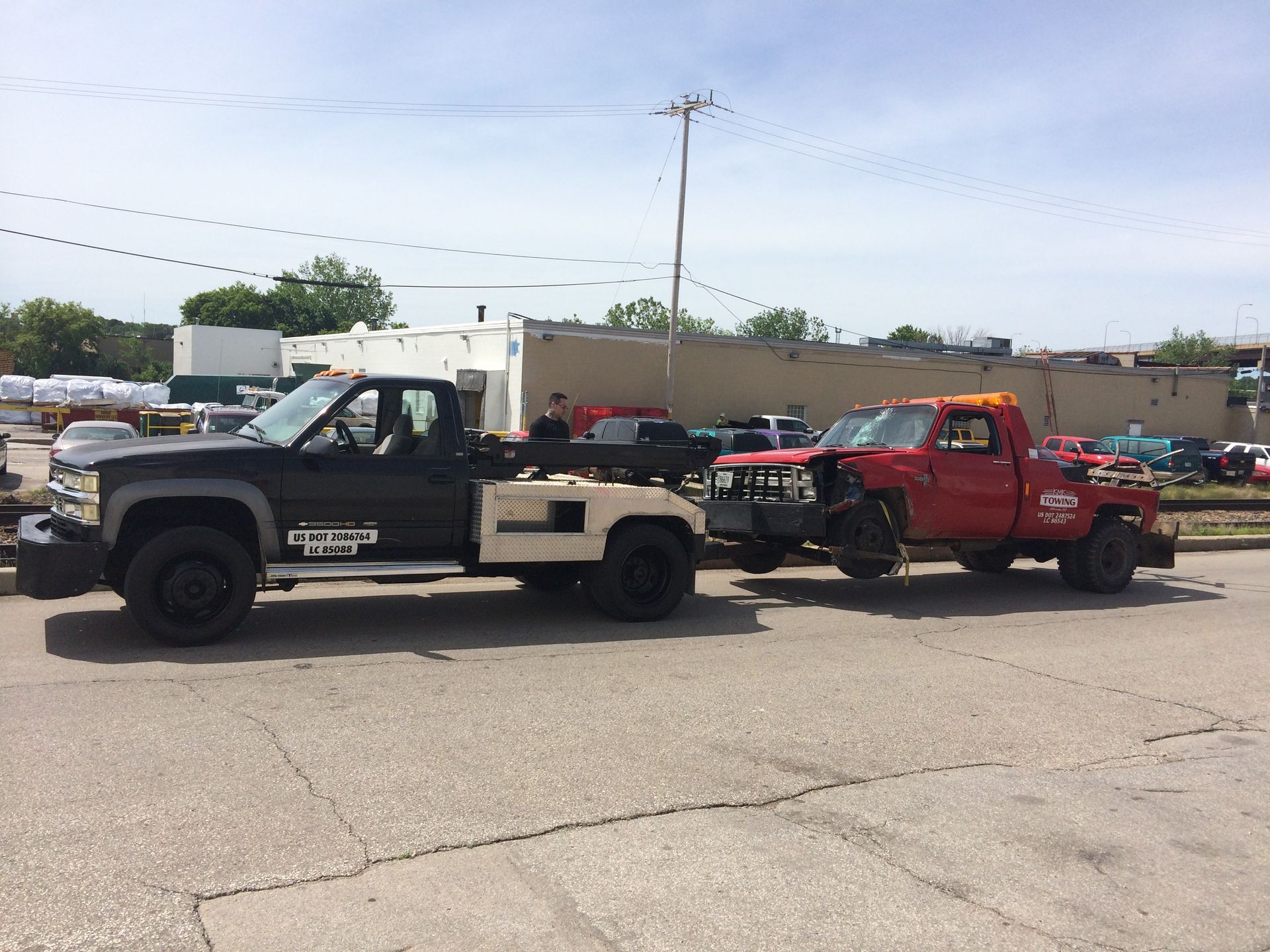 Two tow trucks are parked next to each other in a parking lot.