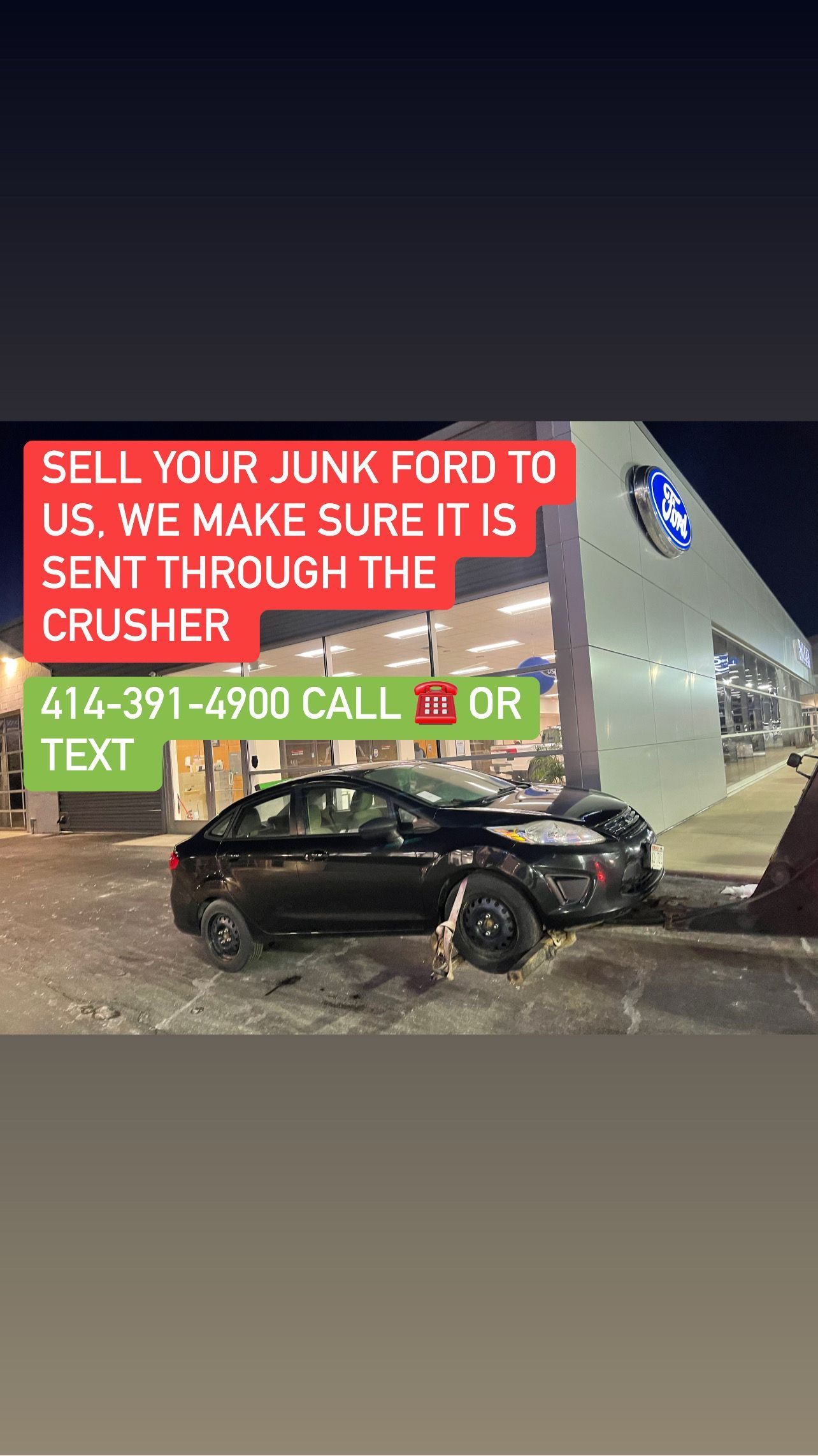 A car is sitting in front of a ford dealership.