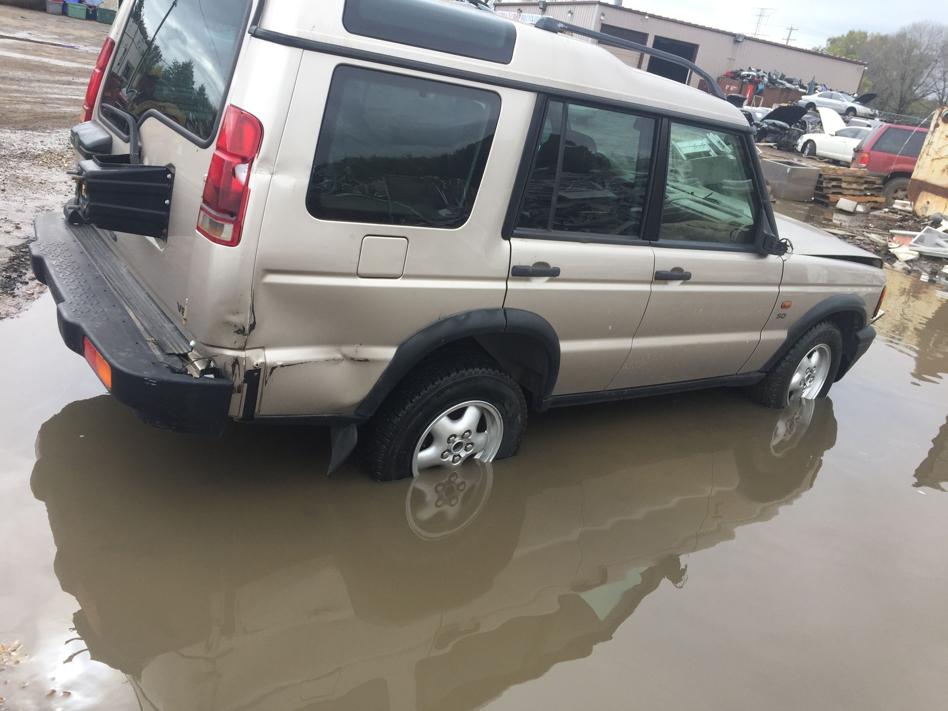 A land rover discovery is sitting in a puddle of water.