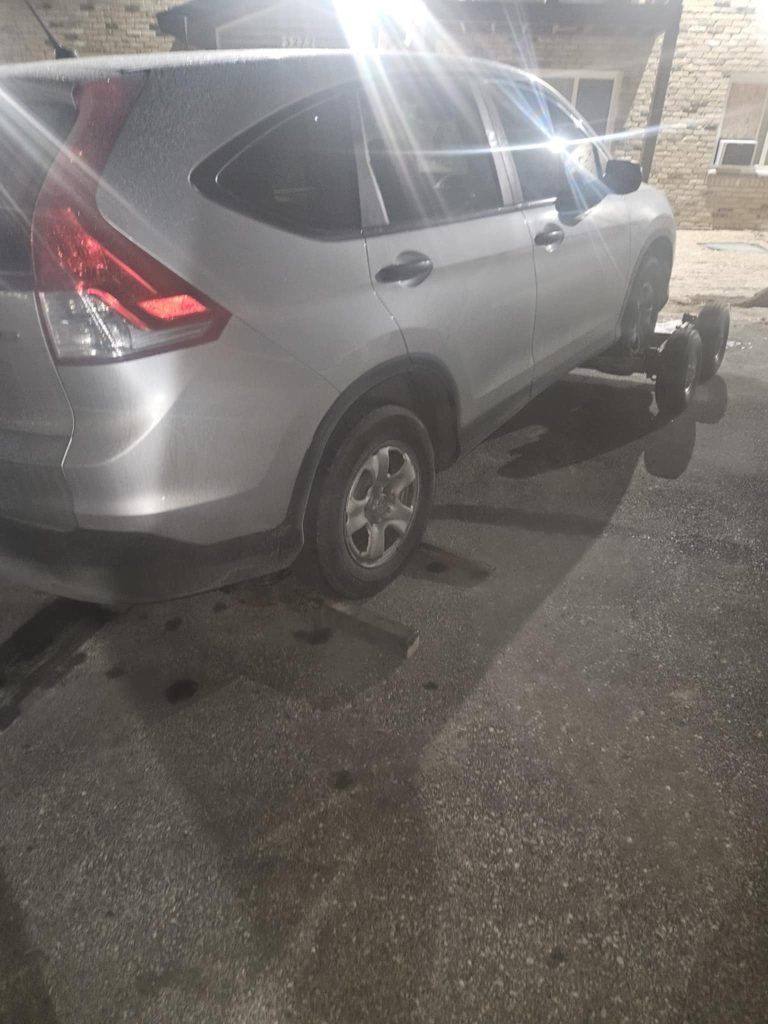 A silver car is parked on the side of the road.