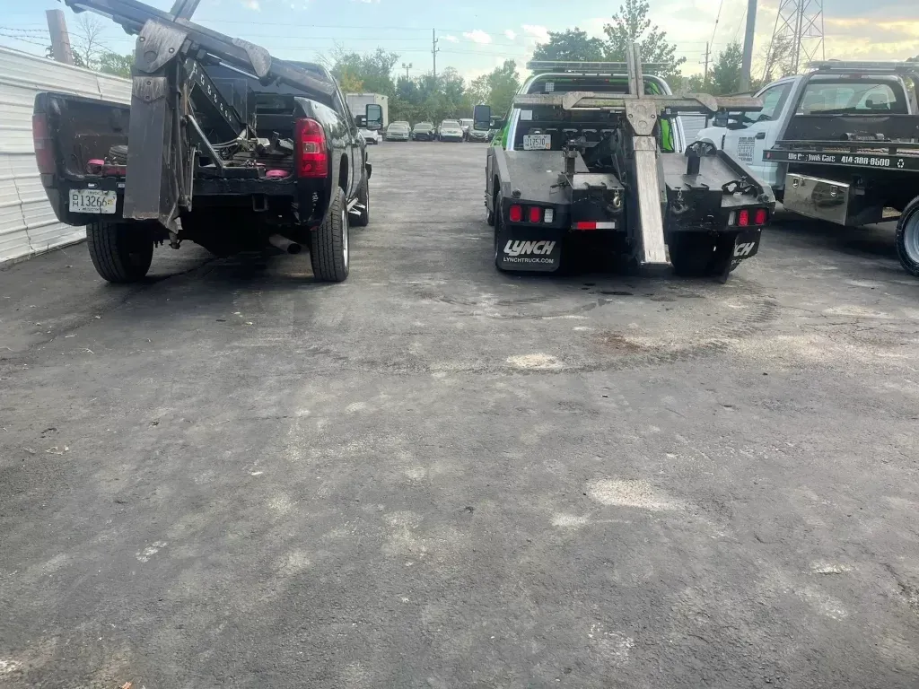 Two tow trucks are parked next to each other in a parking lot.