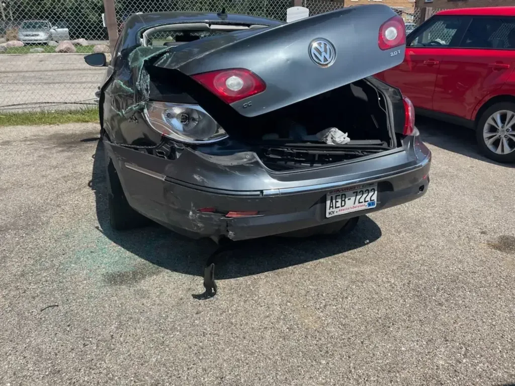 A car with the trunk open is parked in a parking lot.