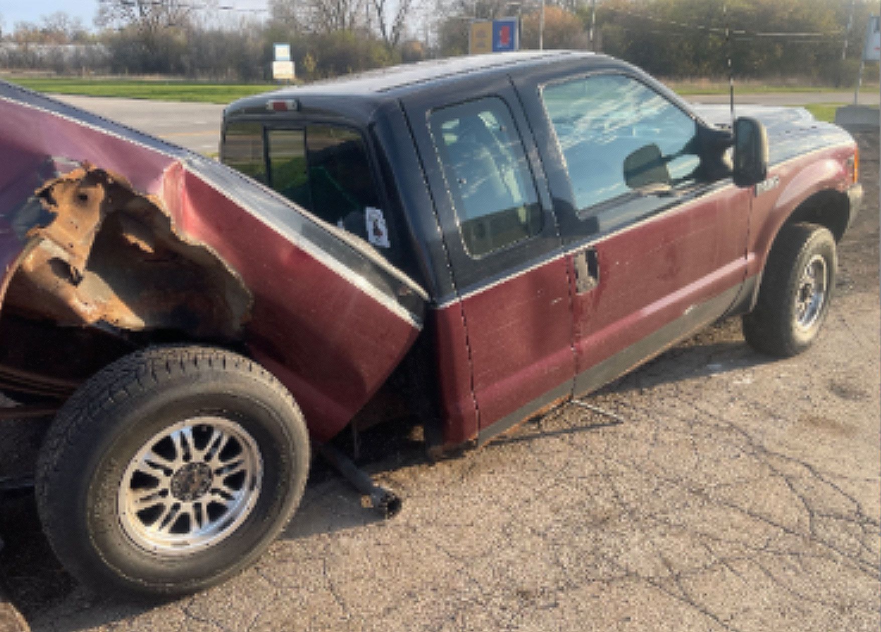 A red truck is sitting on the side of the road.