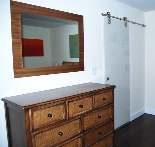 A wooden dresser with a mirror above it