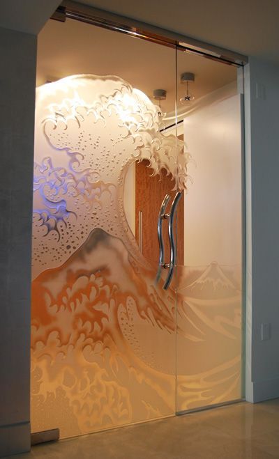 A glass door with a painting of a wave on it.