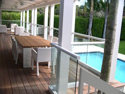 A deck with a table and chairs next to a pool