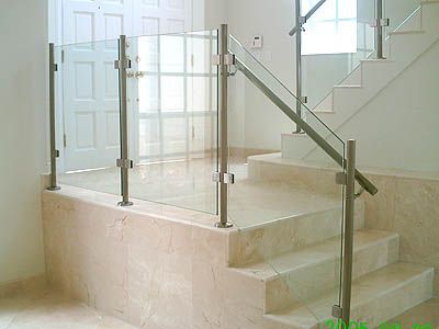 A staircase with a glass railing and marble steps.