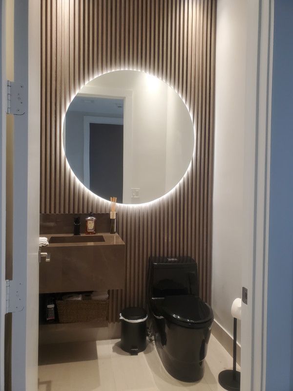 A bathroom with a toilet , sink and mirror.