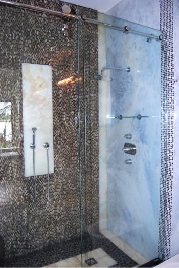 A bathroom with a sliding glass shower door