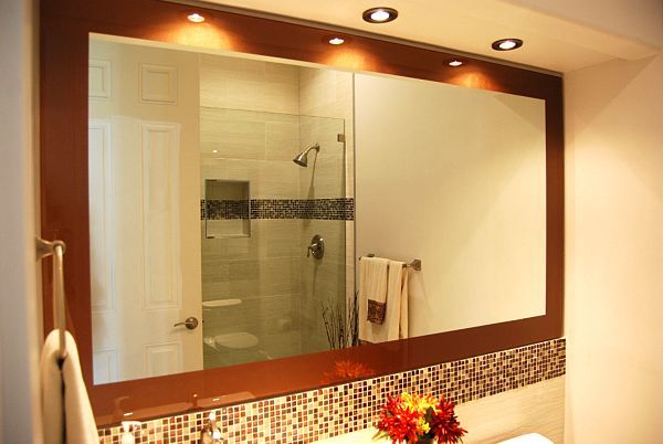 A bathroom with a large mirror and a walk in shower