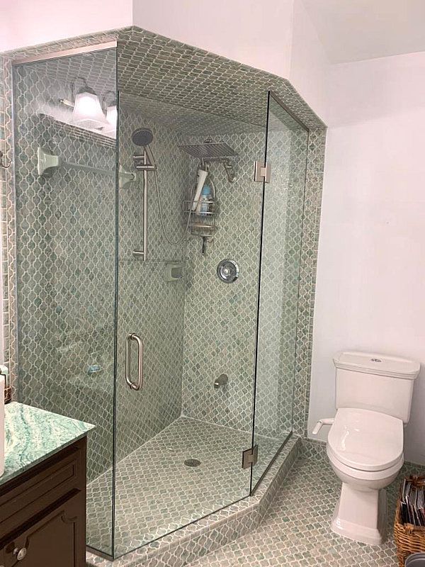 A bathroom with a walk in shower , toilet and sink.