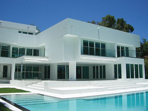 A large white house with a swimming pool in front of it
