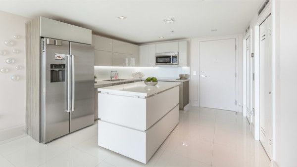 A kitchen with stainless steel appliances and white cabinets