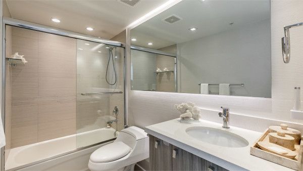 A bathroom with a toilet , sink , tub and shower.