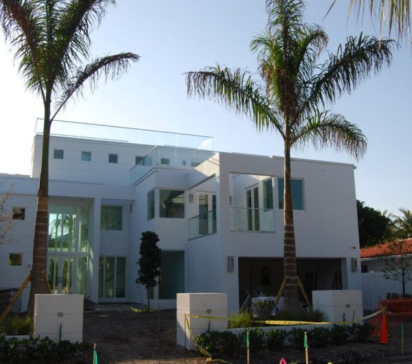 A large white house with palm trees in front of it