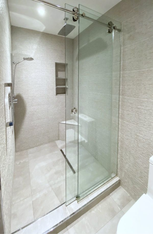A bathroom with a sliding glass shower door and a toilet.