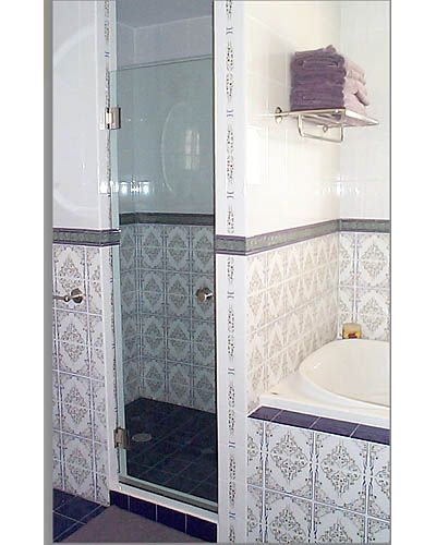 A bathroom with a bathtub and a shower with a glass door