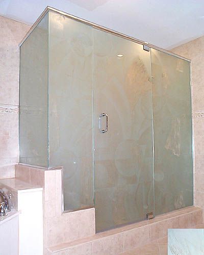 A bathroom with a shower stall with a sliding glass door.