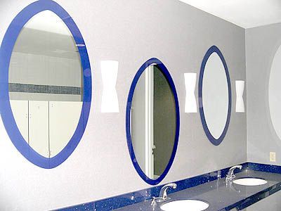 A bathroom with blue oval mirrors and two sinks