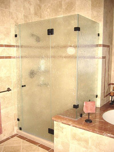 A bathroom with a glass shower door and a sink.