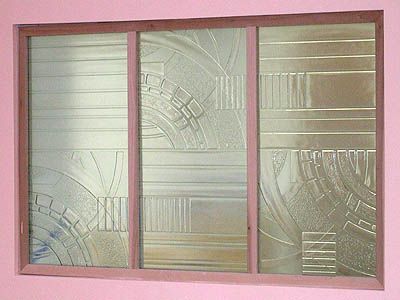 A pink window with a stained glass design on it