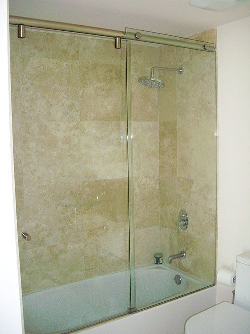 A bathroom with a bathtub and a shower with a sliding glass door