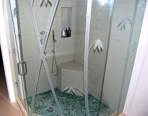 A shower stall with a bamboo design on the glass