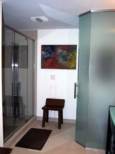 A bathroom with a chair and a painting on the wall