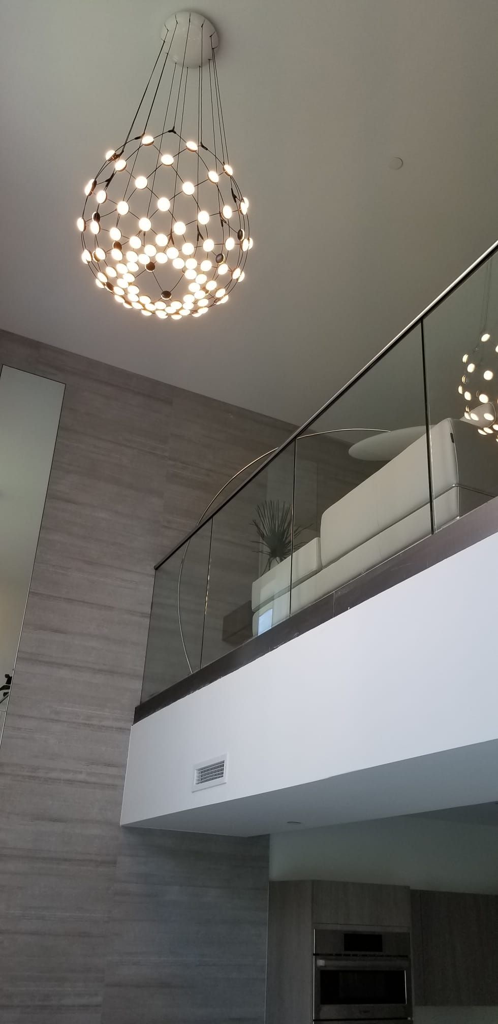 A chandelier is hanging from the ceiling above a balcony.