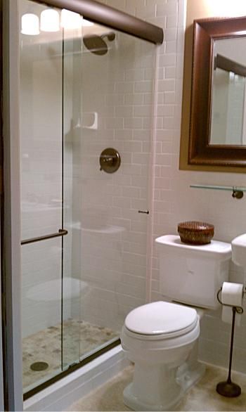 A bathroom with a toilet and a shower stall