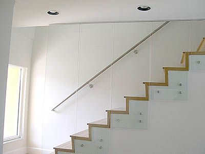 A set of stairs with a glass railing and a window.