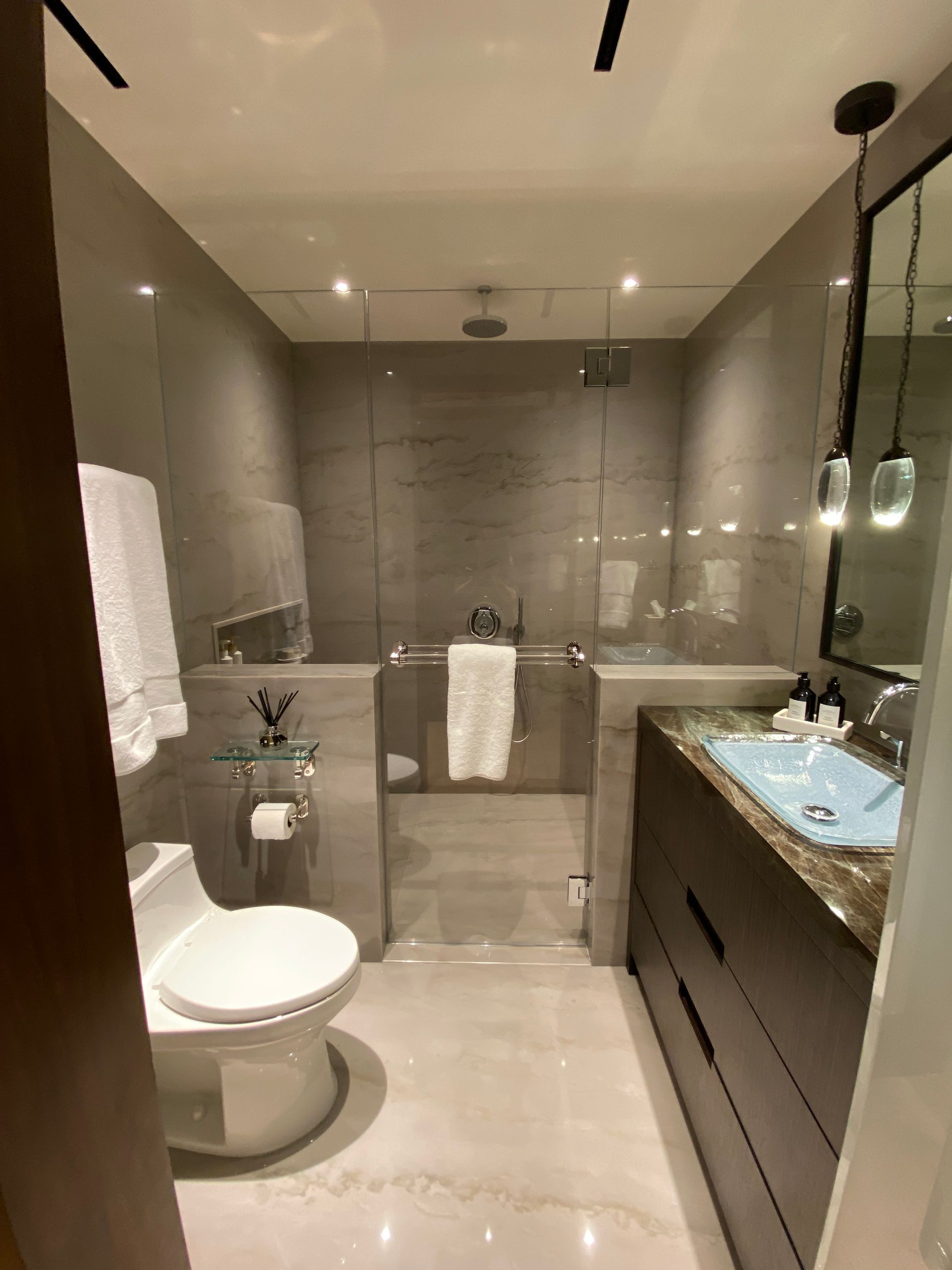 A bathroom with a toilet, sink, and shower.