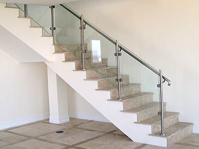 A staircase with a glass railing in a room.