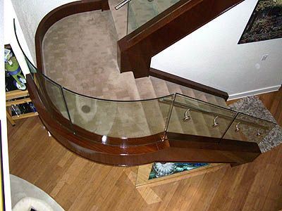 An aerial view of a curved staircase with a glass railing